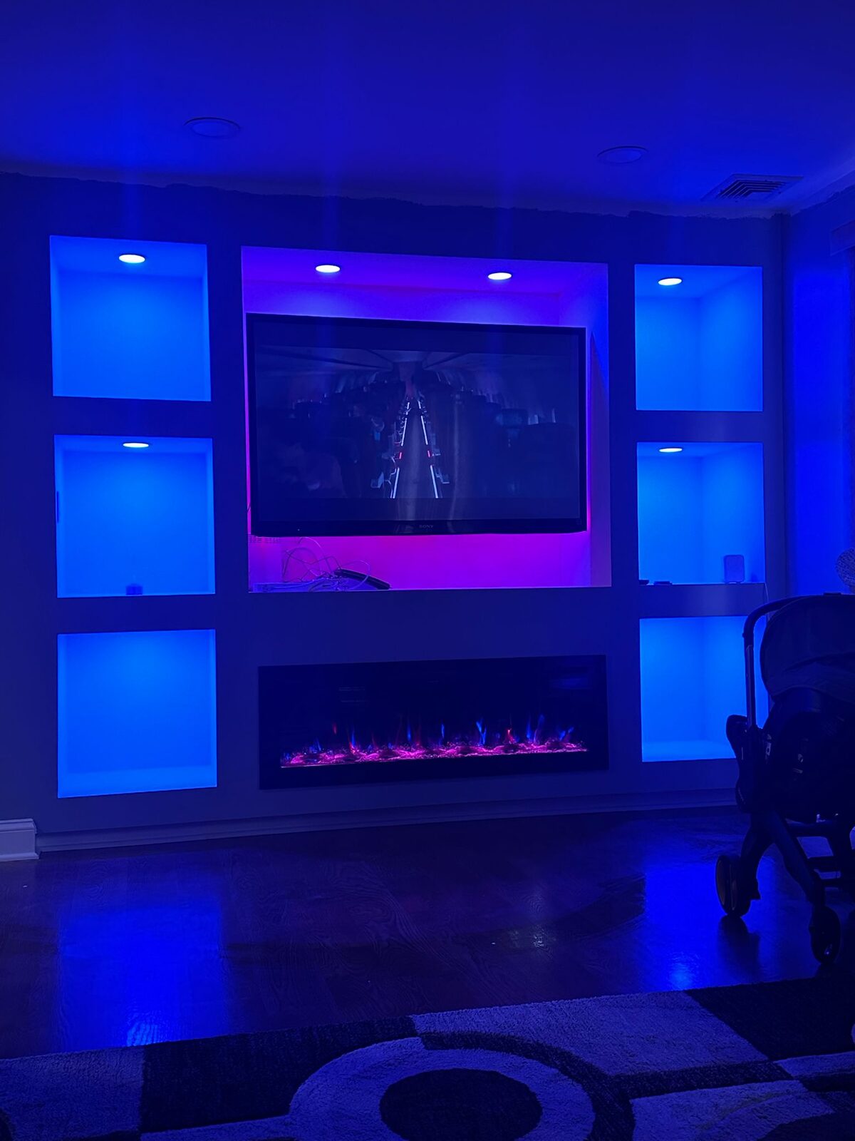 Custom media wall with illuminated built-ins and fireplace